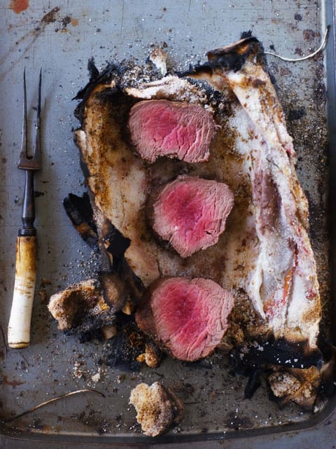 Pink slices of beef tenderloin in a broken salt crust